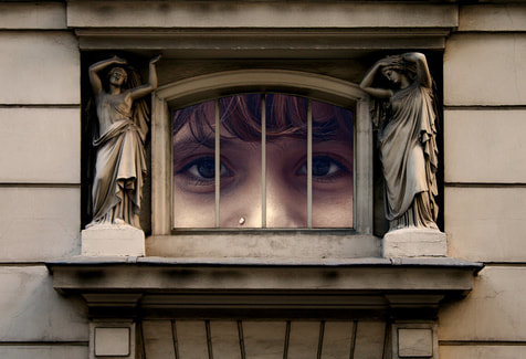 person looking through window with angels