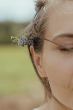 woman's ear with flowers behind it, eyes closed, spiritual