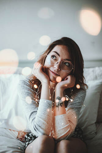 woman sitting, thinking, with sparkly lights