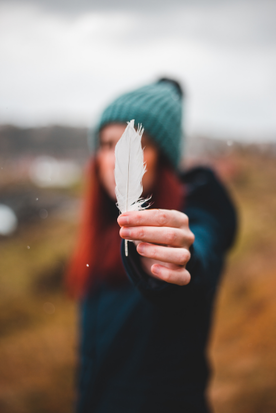 woman holding a white feather