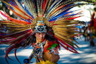 native american man wearing lots of tribal feathers
