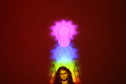 woman in front of picture of aura of different colors