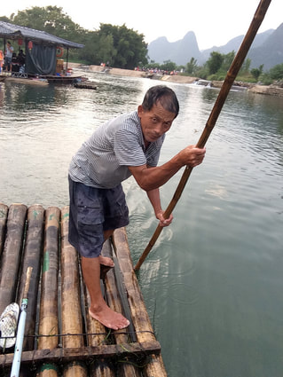 man pushing wooden oar floating raft