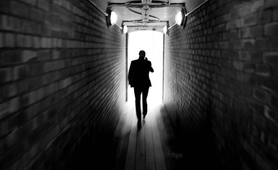 man walking towards light