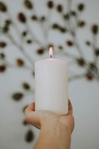 hand holding white candle of hope, imbued with healing and positive energy