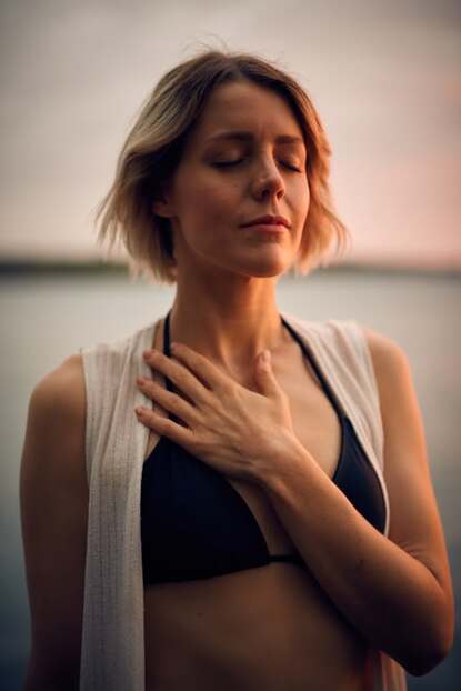 woman meditating with hand on heart