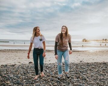 two women on beach smiling