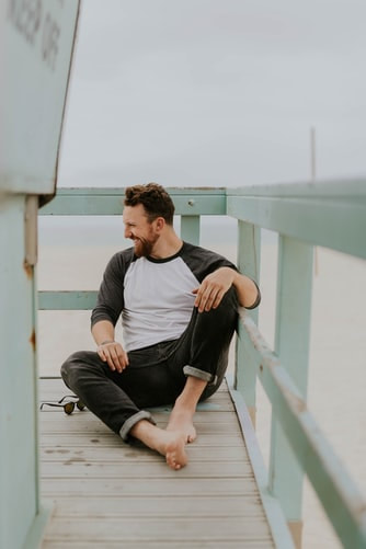 Happy man feeling joy sitting on white dock