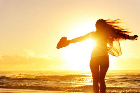 spiritual woman in sunset holding heart