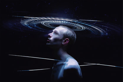 man looking up at light in black space with spheres