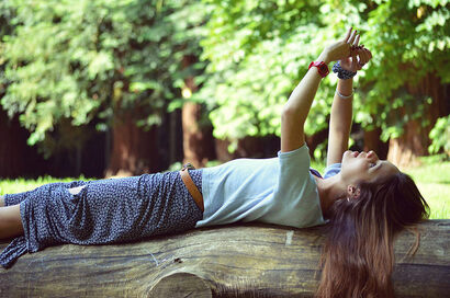 inspired womman lying on log in nature