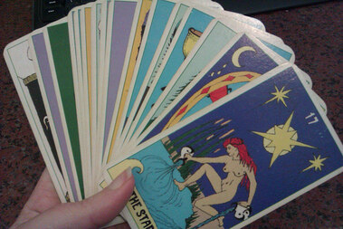hand holding spiritual tarot cards fanned out