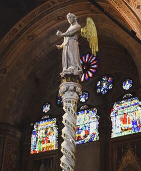 archangel statue in church with stained glass windows