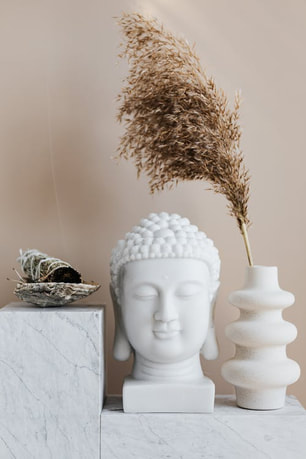 beautiful sacred space display of buddha statue, sage and vase on marble