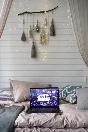 beautiful bedroom sacred space with 'dream' on laptop and dreamcatcher hanging piece on wall