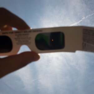 solar eclipse glasses and bright sky