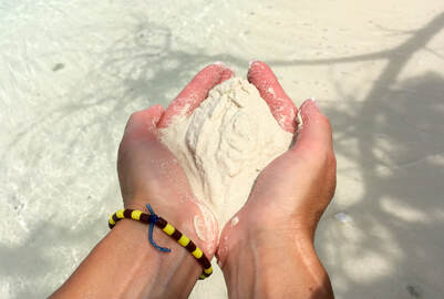 hands holding sand in a sacred way