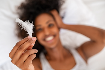 happy woman holding white feather
