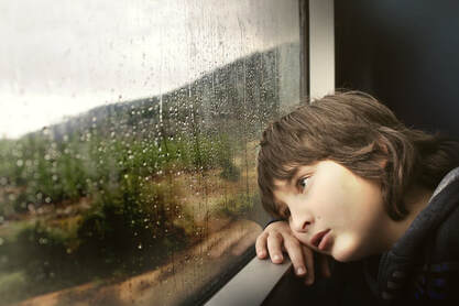 sad child looking out window