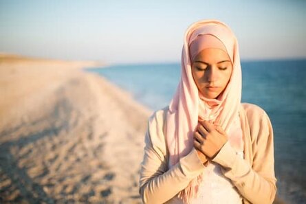 energy healing woman, hands over heart at beach
