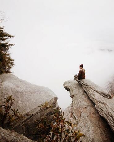 woman sitting on edge of rock