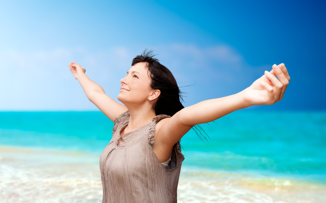 woman arms up receiving energy at beach