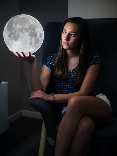 woman holding moon in hand, cosmic energy