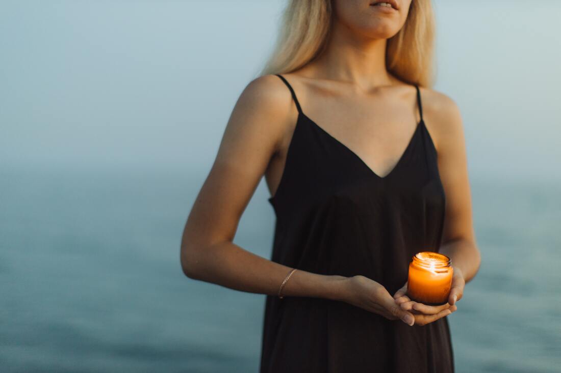 spiritual woman, sacred candle ritual on beach